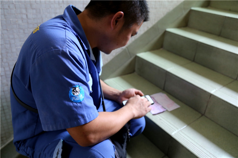 客戶還是沒(méi)有到，家具安裝謝師傅蹲在門口等，一邊等一邊處理今天要去的下一家客戶的資料